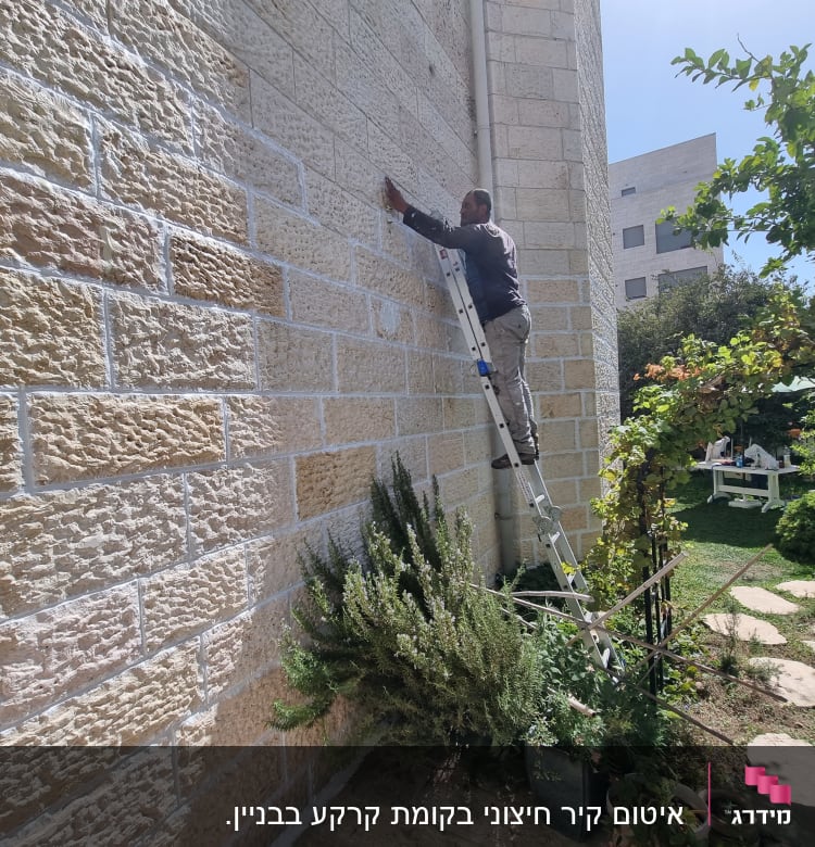 אדם על סולם אוטם קיר חיצוני באיטום